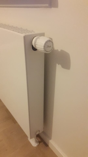 Radiator med termostat installeret som del af effektiv varmeløsning i bolig