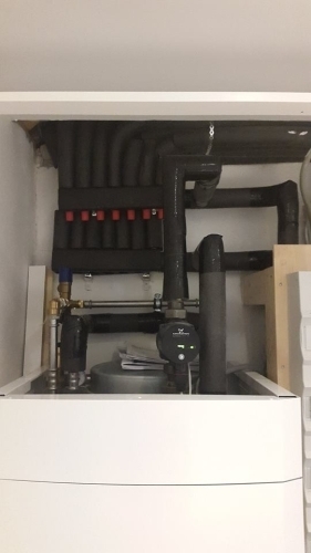 Varmeanlæg placeret i teknikskab med pumper og rørføring til opvarmning